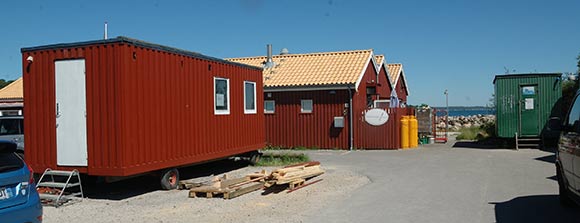 Helårsbadernes ny midlertidige skurvogn på Nivå Havn, kan ikke - som krævet - bære et tegltag som det der ses i baggrunden på Restaurant Trekosten. Til højre den gamle grønne skurvogn