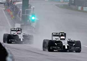 Kevin Magnussen foran Jenson Button i regnevejr. Foto: McLaren